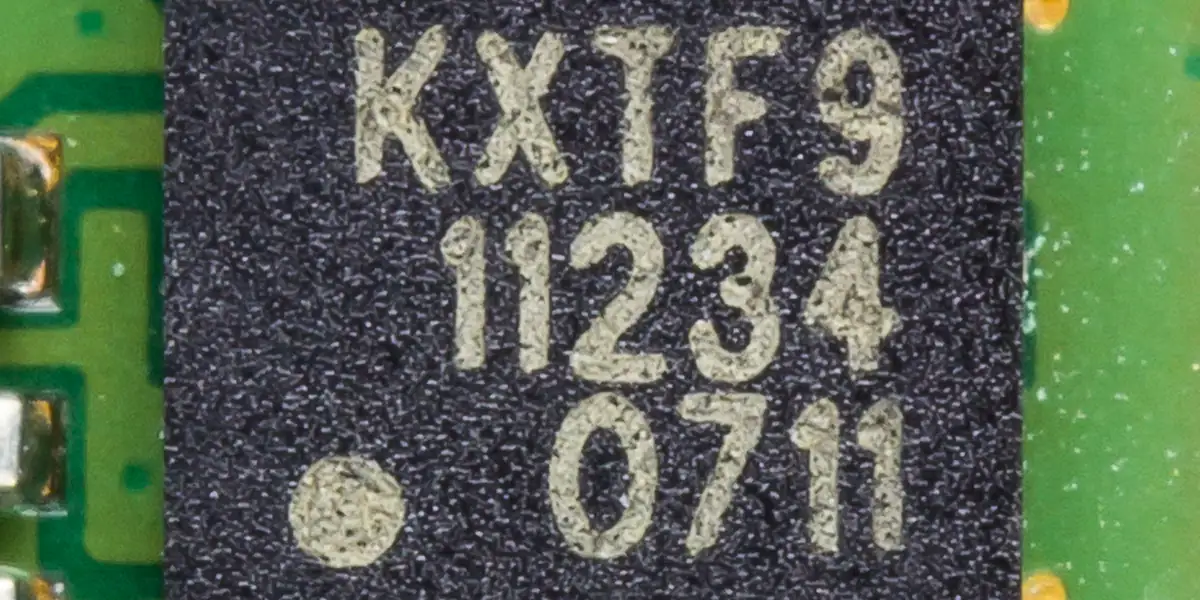 Macro d'un secure element MEMS Kionix sur PCB vert, élément matériel typique d'une chaîne de cybersécurité IoT.