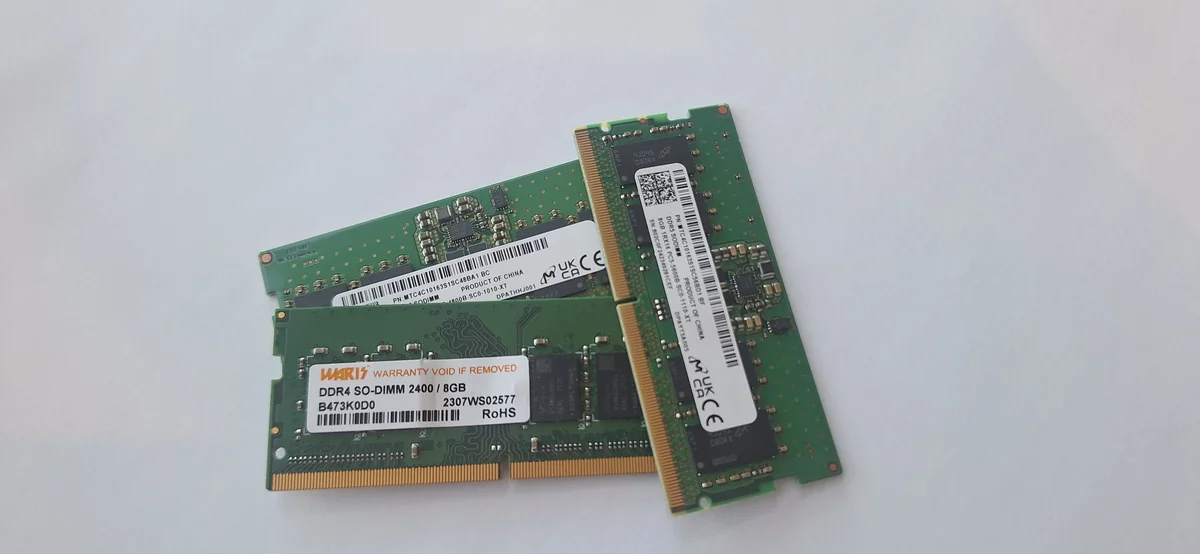 Comparaison côte à côte d'un module SO-DIMM DDR4 WARIS 2400 MHz 8 Go et d'un module SO-DIMM DDR5 Micron sur le banc AESTECHNO, marquages CE / UK CA / RoHS visibles, encoches de détrompage en positions différentes.