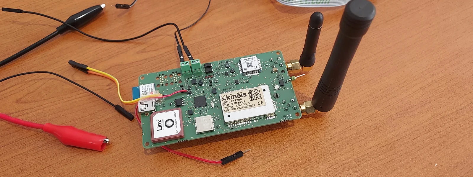 Prototype IoT Kinéis en cours de développement firmware chez AESTECHNO : carte embarquant un module satellite, antennes RF et GPS, alimentation batterie 18650 et sondes de mesure connectées.