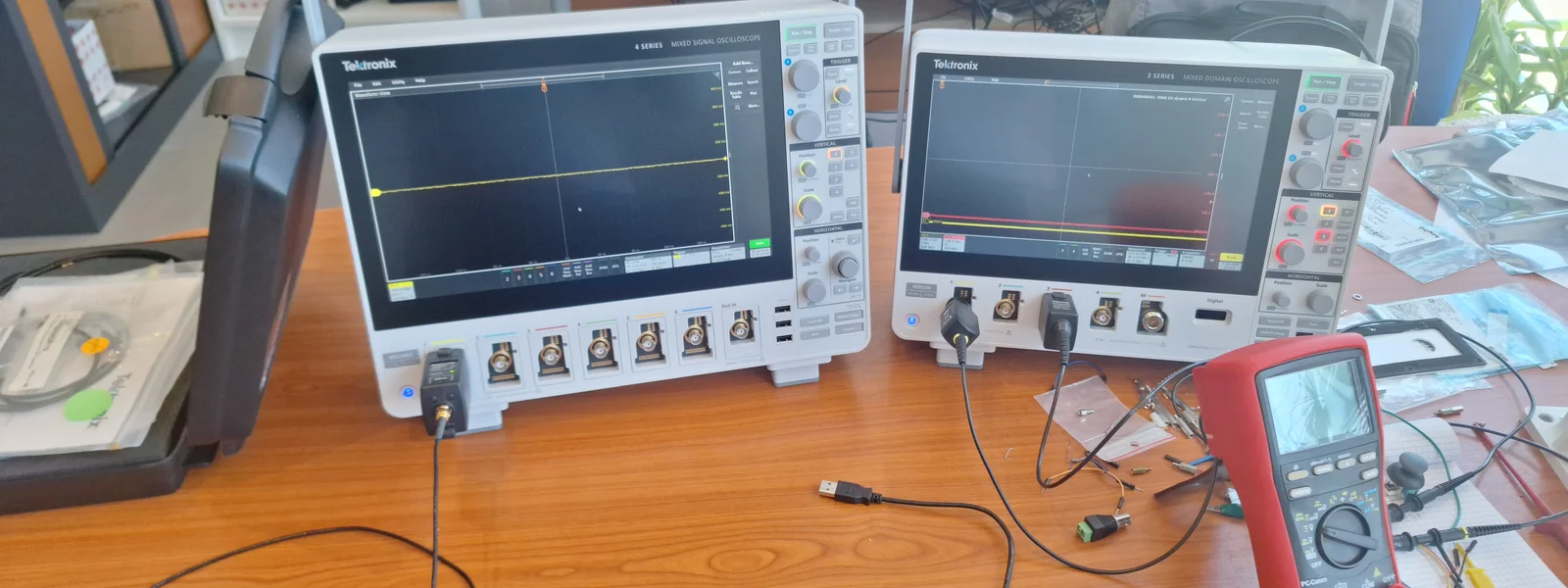 Banc d'instrumentation AESTECHNO à Montpellier : deux oscilloscopes Tektronix MSO (4 series + 3 series) et multimètre Fluke alignés sur l'établi pour caractérisation hardware multi-canaux.
